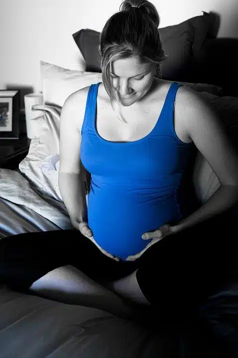 a pregnant woman tenderly holding her stomach