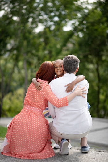 happy couple and adoptive child hugs  to demonstrate Openness in Adoption