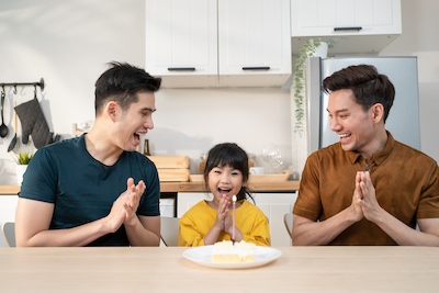 happy asian lgbtq family with adopted daughter