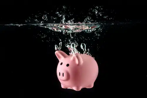 piggy bank submerged in water with a black background