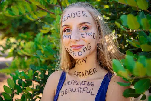 a woman with positive writings on her face and neck