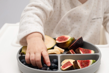 kid with special needs eating a bowl of healthy fruits for dietary and nutritional needs