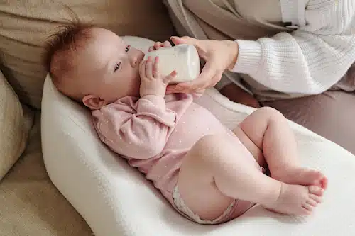 a baby drinking milk from the baby bottle