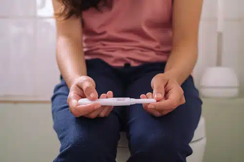 woman holding a pregnancy test in the bathroom