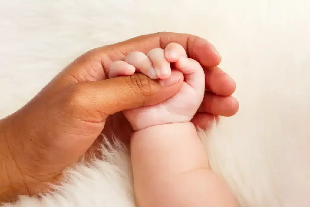 Mother holding the hand of a new born baby