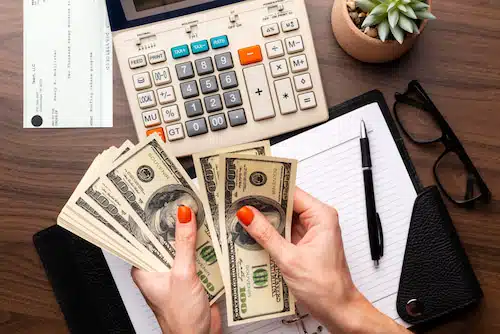 calculator and budget planner on a table while assessing living expenses