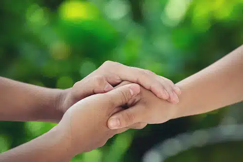 two hands holding showing support for each other