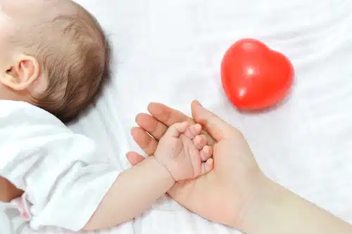 mother holding hands with infant