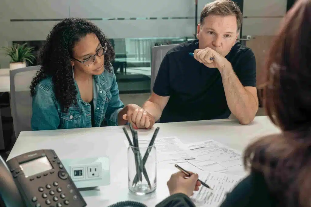 A man and woman review paperwork at a table, discussing the adoption process for twins in Ohio.
